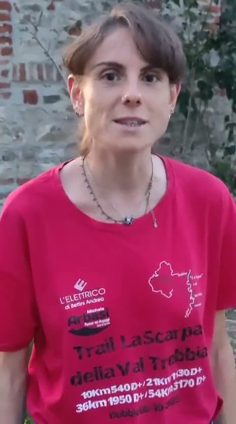 Fotogramma del video: un’atleta parla alla telecamera indossando la maglia di un trail.